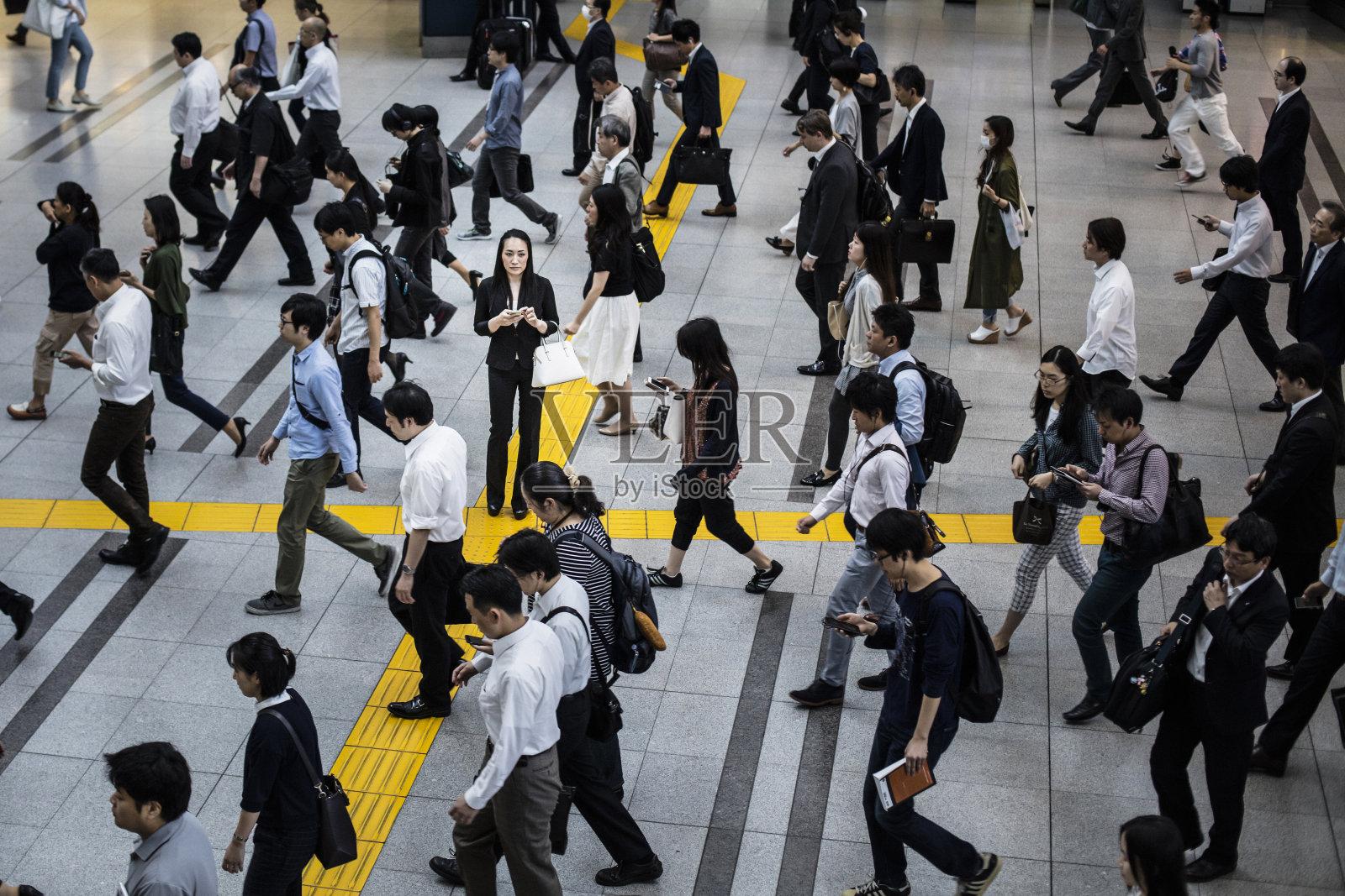 一名日本妇女在通勤者的包围下打电话照片摄影图片