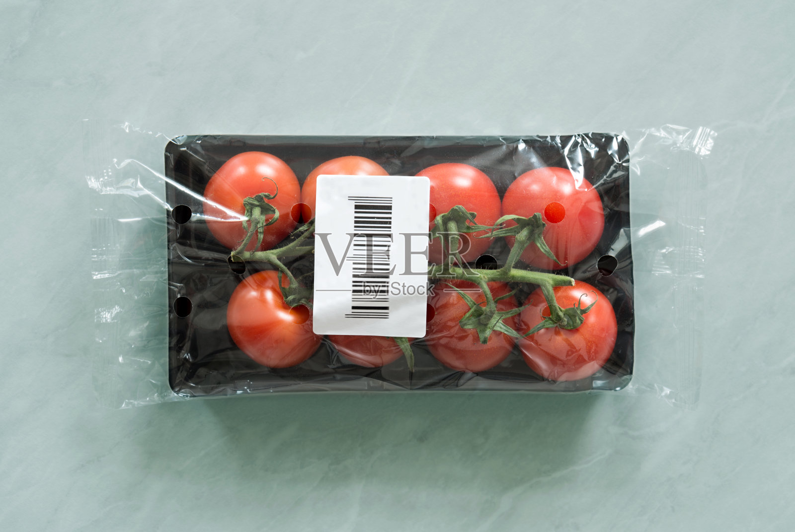 新鲜的有机西红柿在市场包装内与条形码标签照片摄影图片