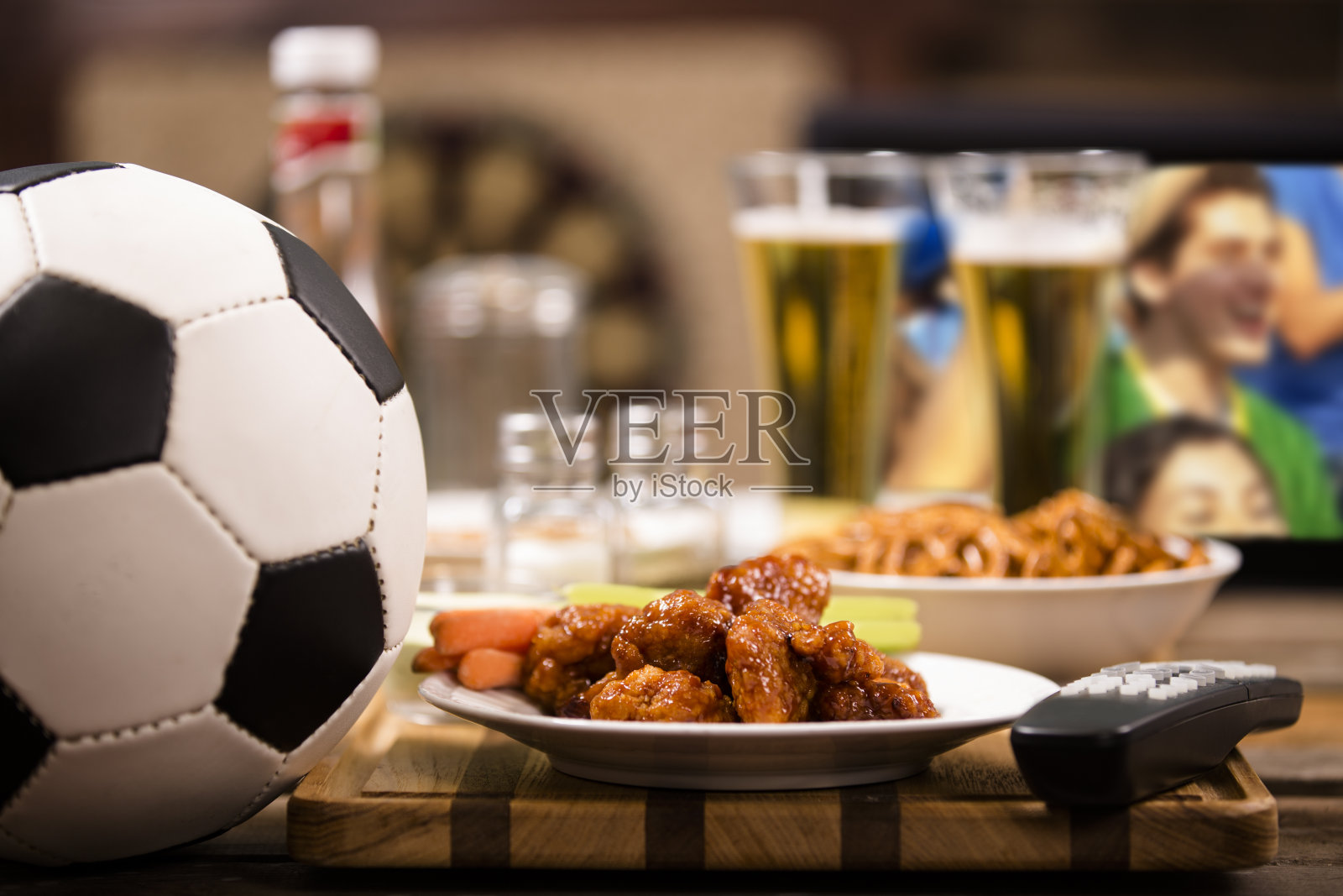 在当地酒吧看电视足球赛。鸡翅膀。照片摄影图片