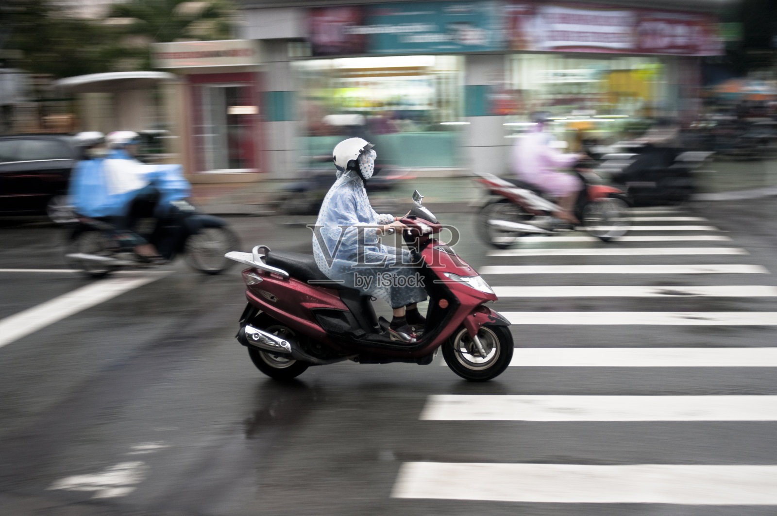 在越南芽庄，在雨中骑摩托车照片摄影图片