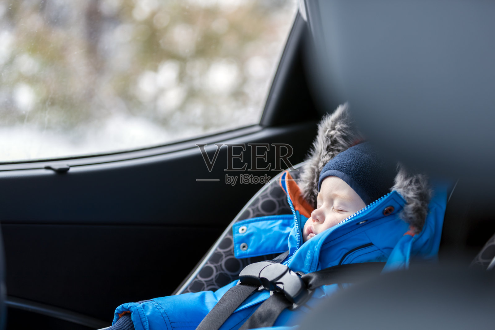婴儿睡在汽车座椅，冬季照片摄影图片