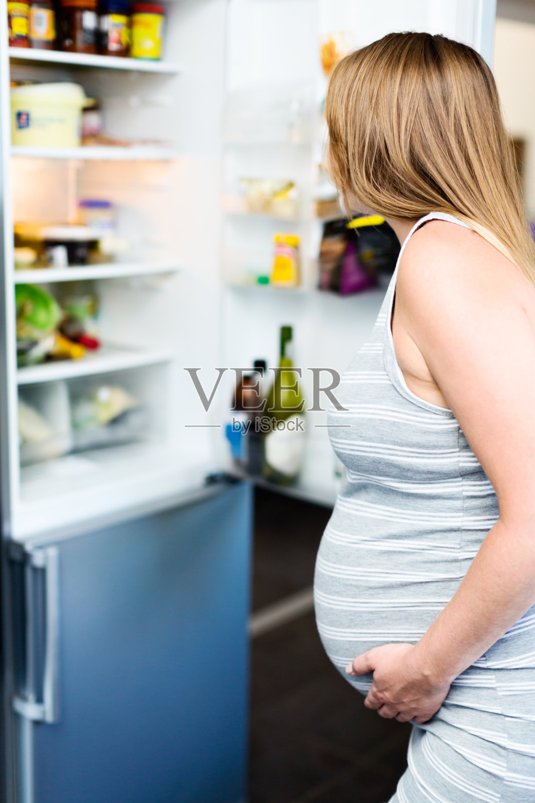饥饿的孕妇在冰箱里寻找零食照片摄影图片