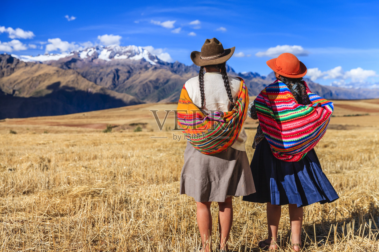 秘鲁妇女穿着民族服装穿过田野，圣谷照片摄影图片