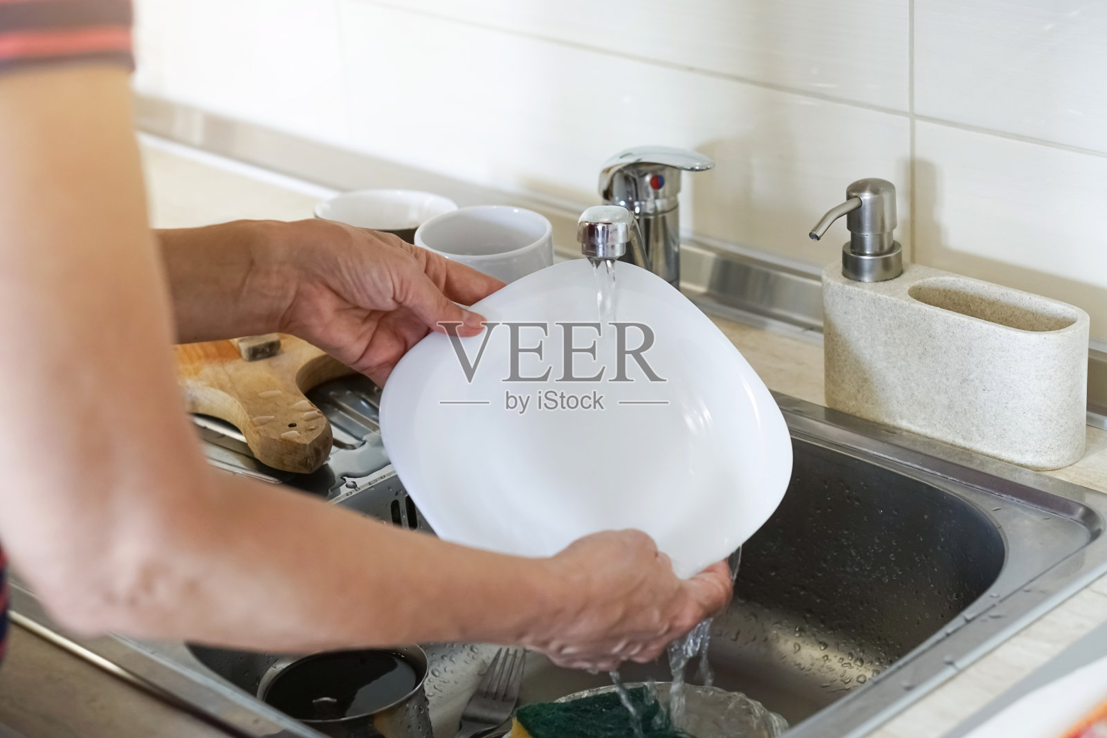 女人的手在厨房洗盘子的特写照片摄影图片