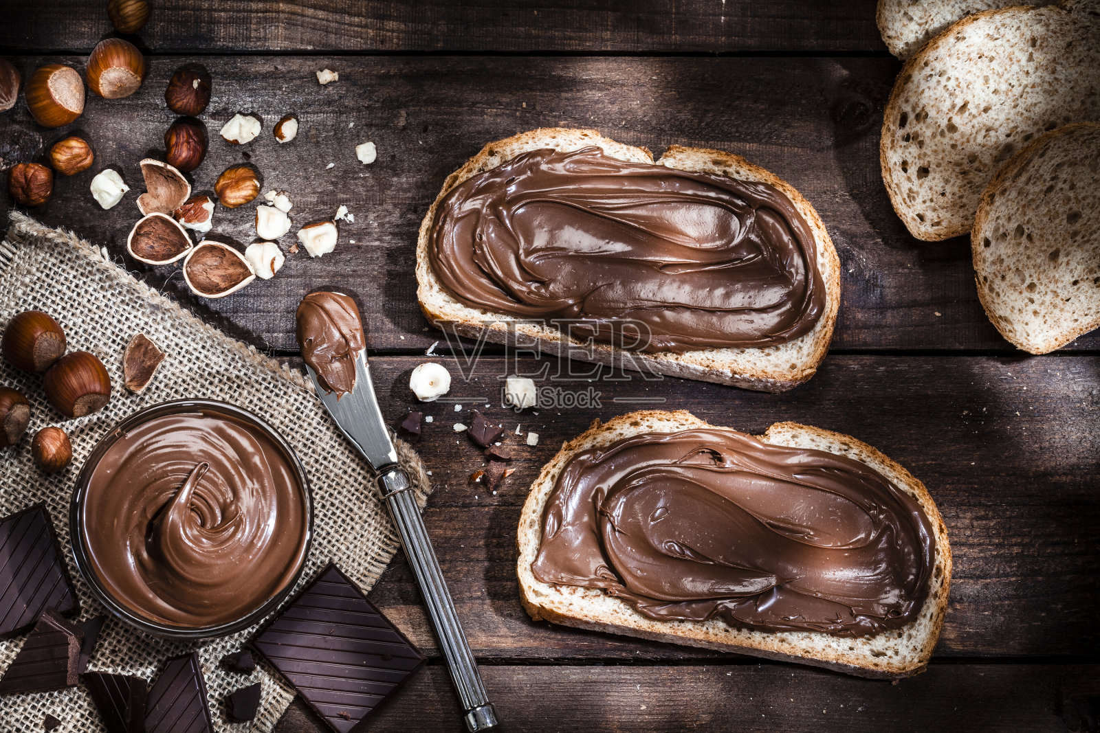 巧克力和榛子的面包片放在质朴的木桌上照片摄影图片