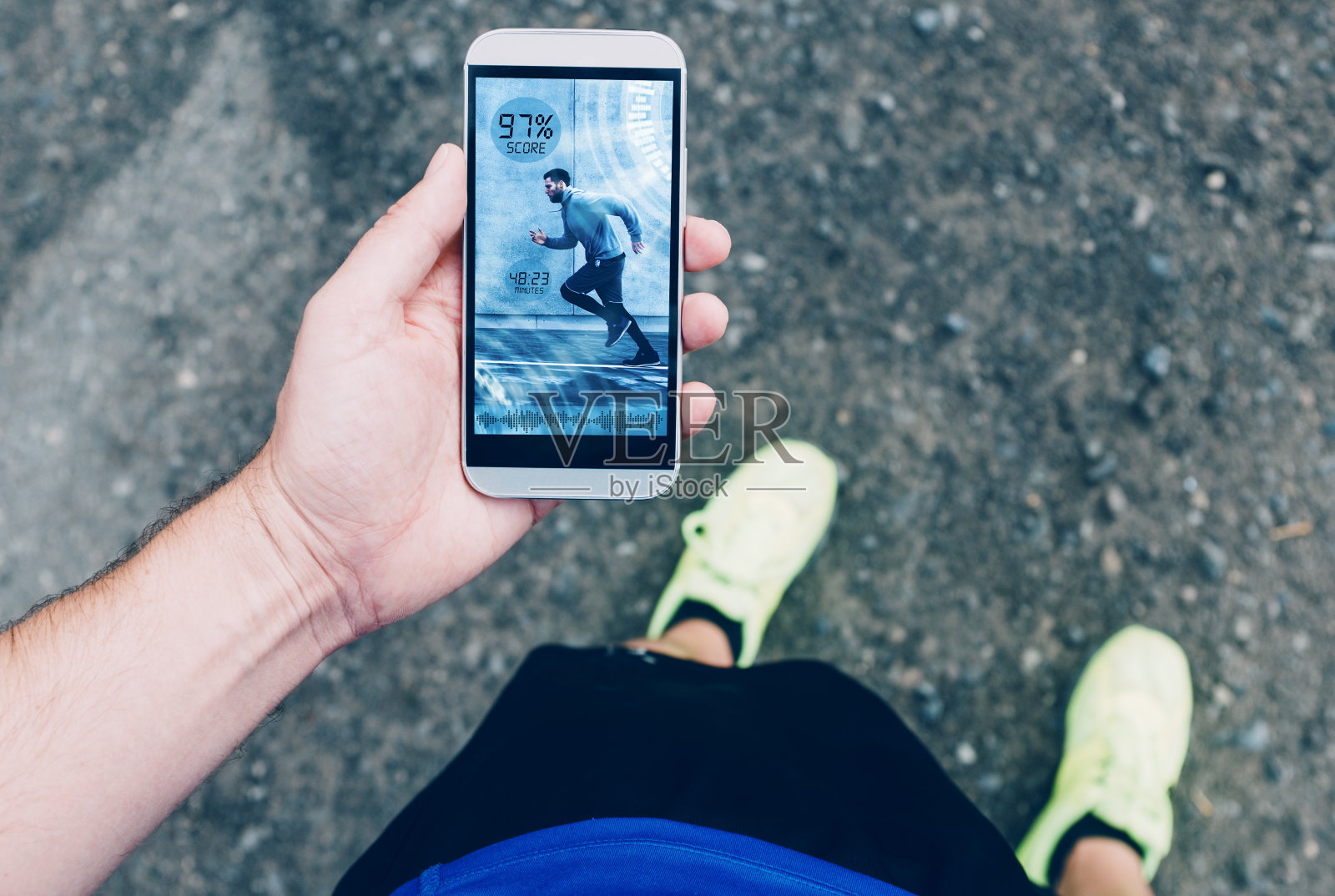 跑步者的观点，同时持有与健身应用程序的手机照片摄影图片