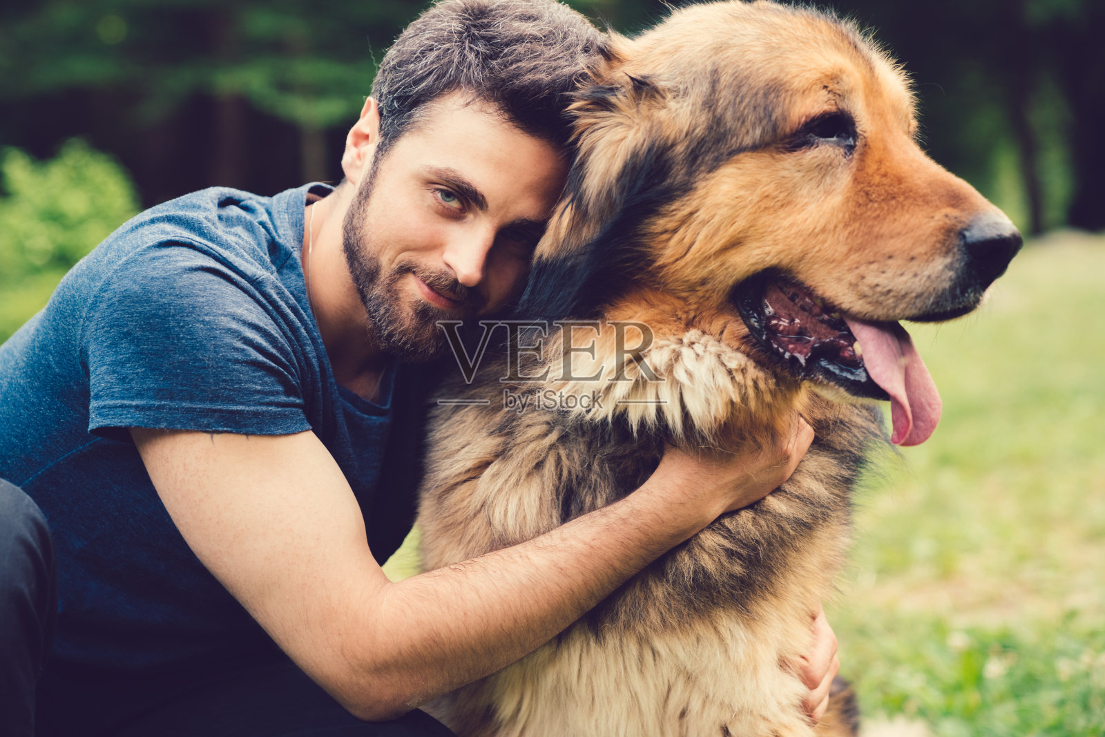 一个年轻人抱着一只狗照片摄影图片