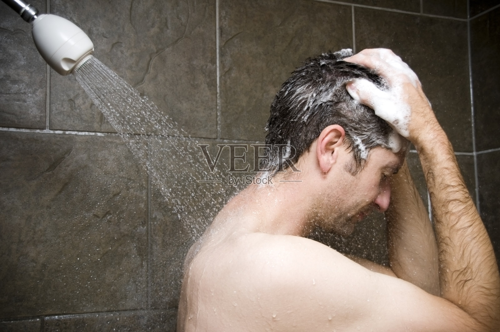 男人洗澡，水冲刷他照片摄影图片