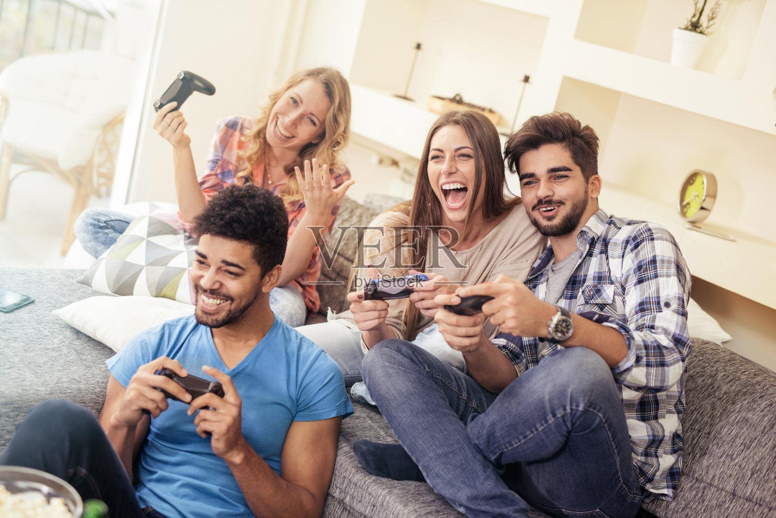 微笑的朋友在家里玩电子游戏照片摄影图片