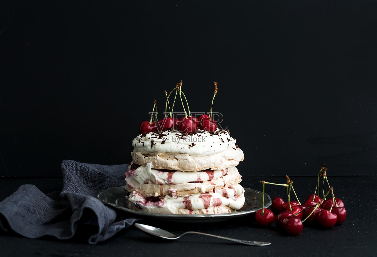 新鲜樱桃、芝士奶油和巧克力片的Pavlova蛋糕照片摄影图片