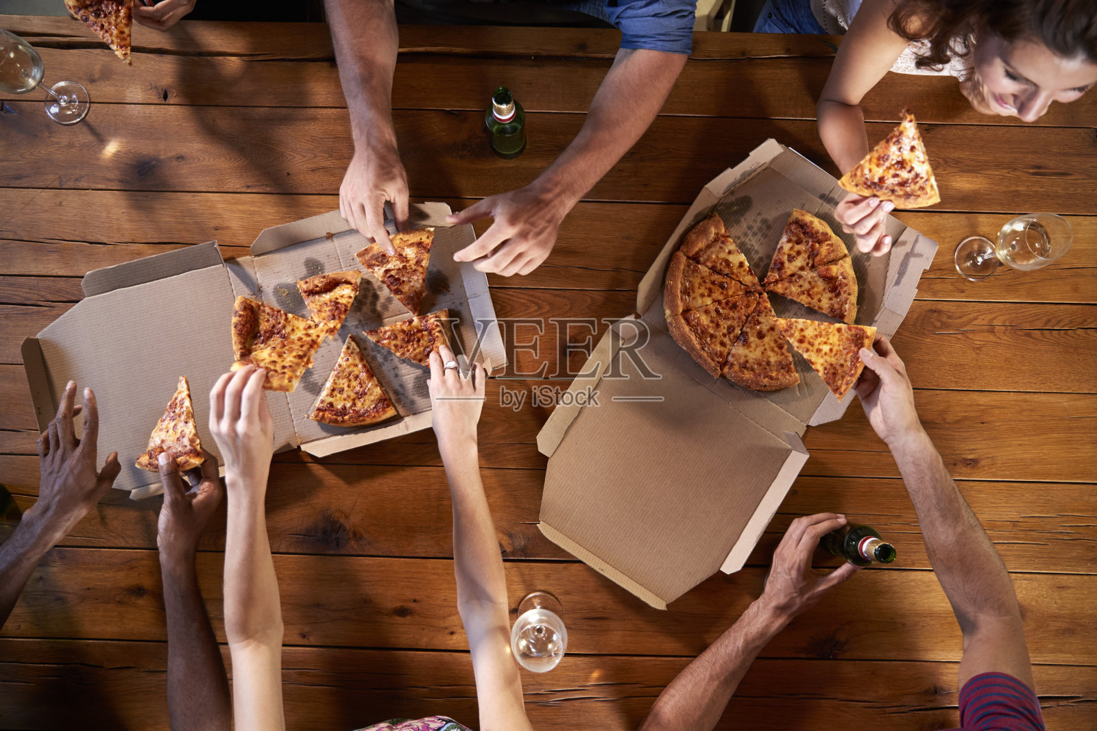 朋友们在餐桌上分享外卖披萨的照片照片摄影图片