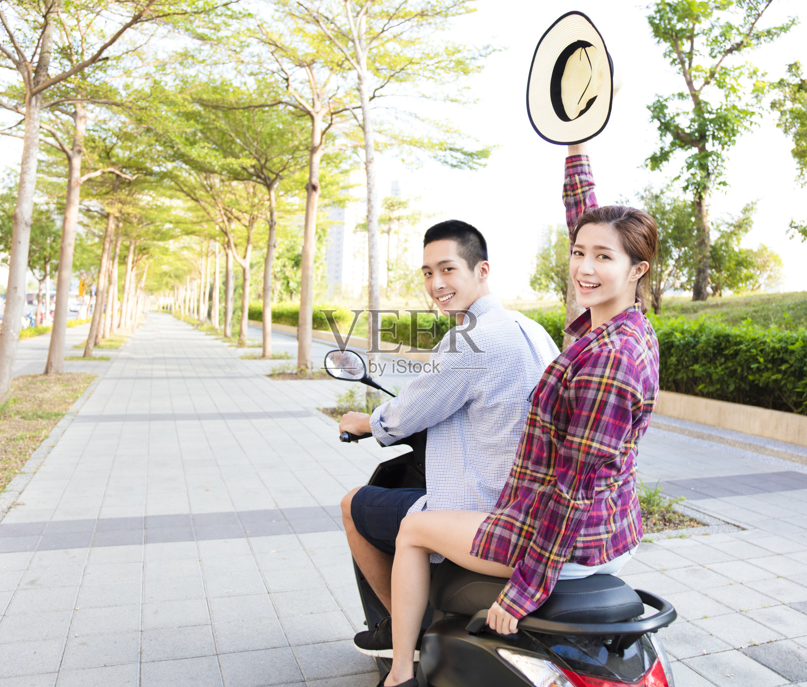 一对快乐的年轻夫妇在镇上骑摩托车照片摄影图片