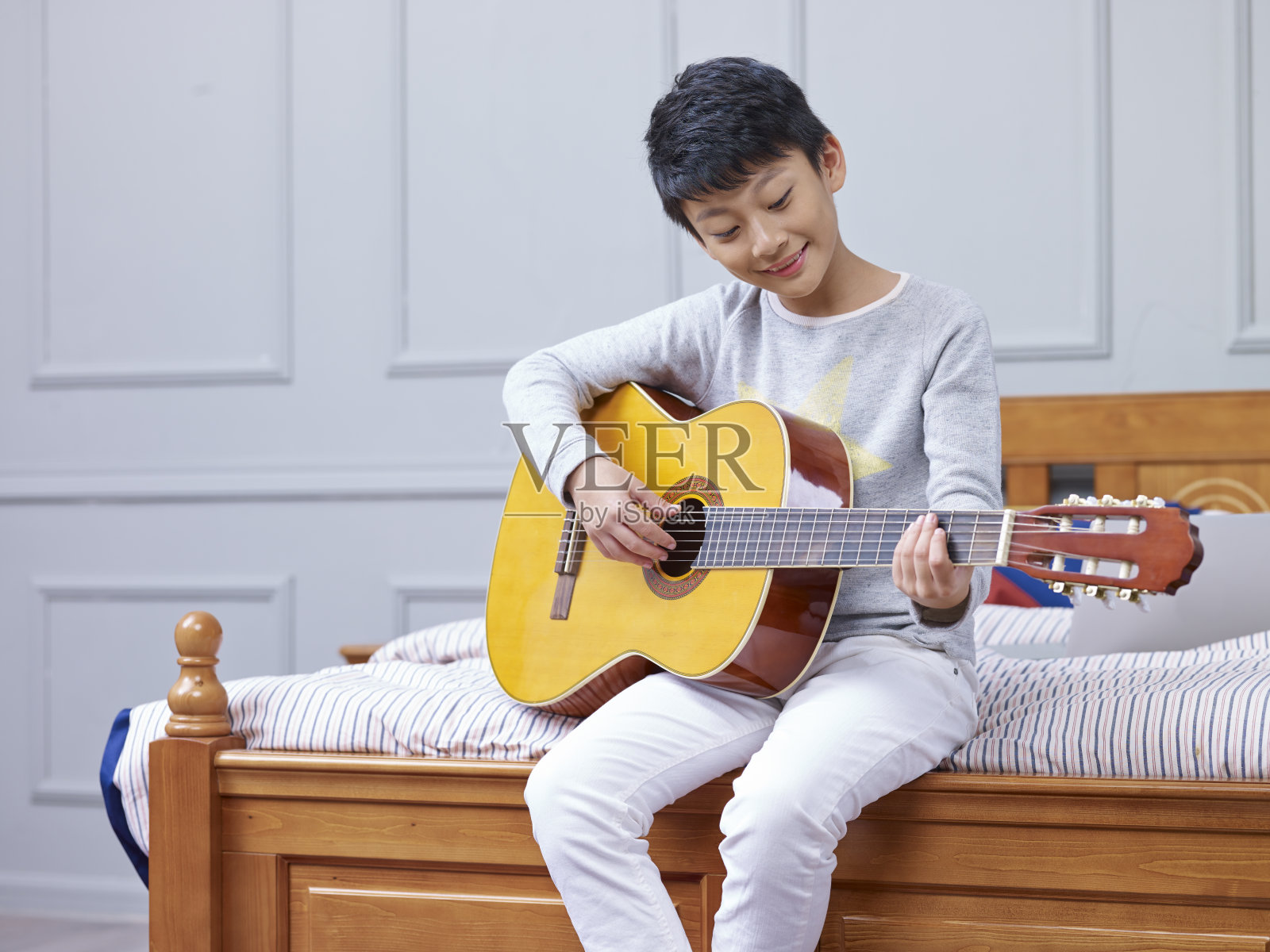 年轻的亚洲男孩微笑，练习，学习弹吉他照片摄影图片
