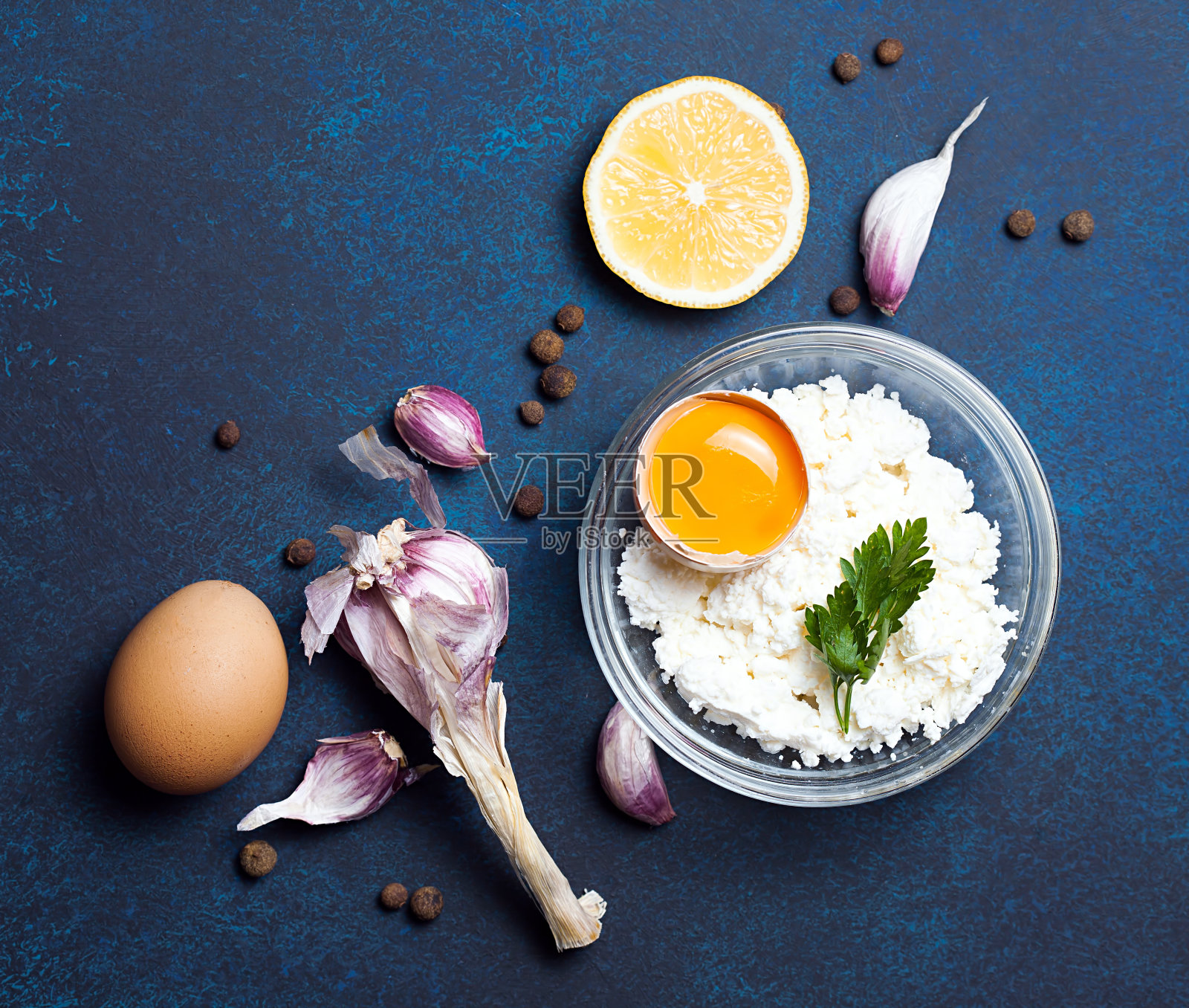食品有机配料:白软干酪。鸡蛋，大蒜和欧芹放在深色的背景上。俯视图，平放照片摄影图片