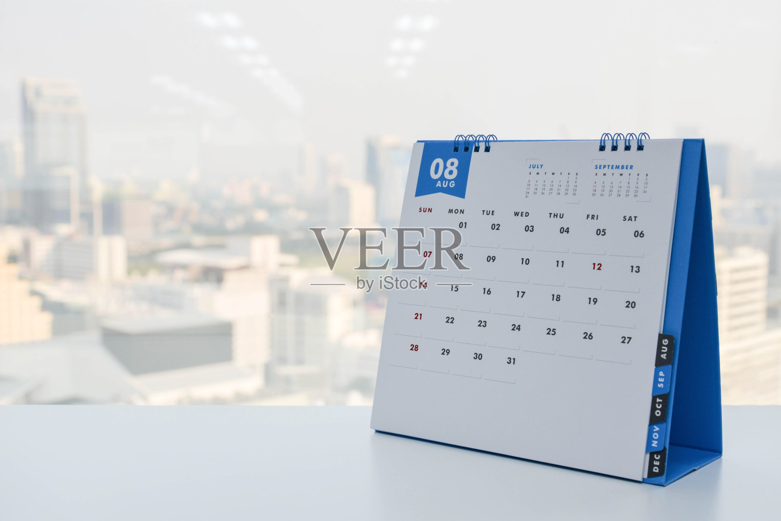 8月日历在白色的桌子上，以城市景观为背景照片摄影图片