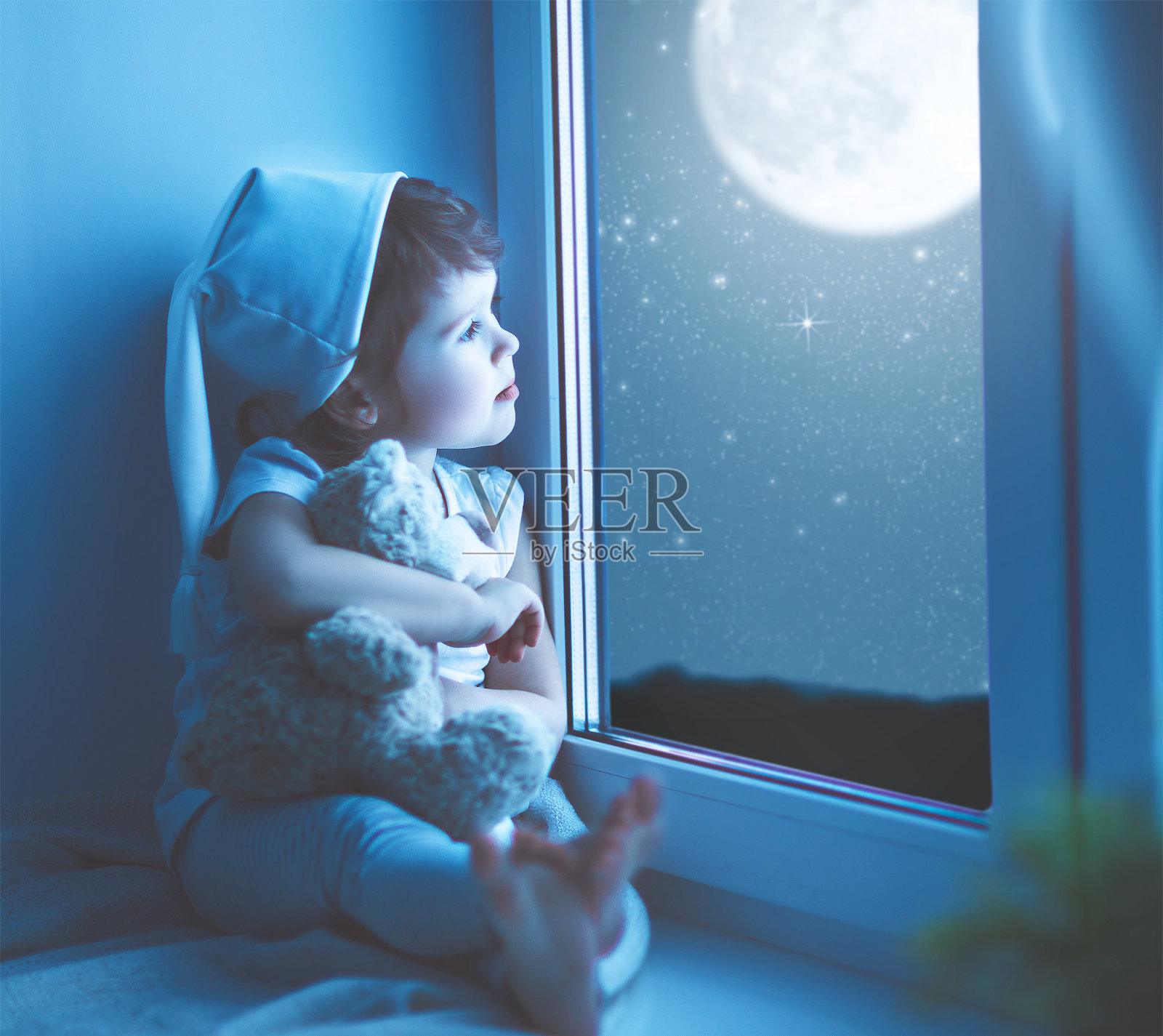 临睡前，窗前的小女孩梦见星空照片摄影图片