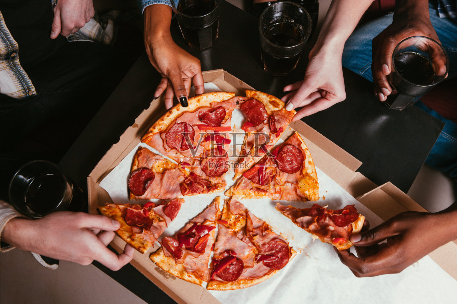 四个朋友结伴在家吃新鲜的披萨照片摄影图片
