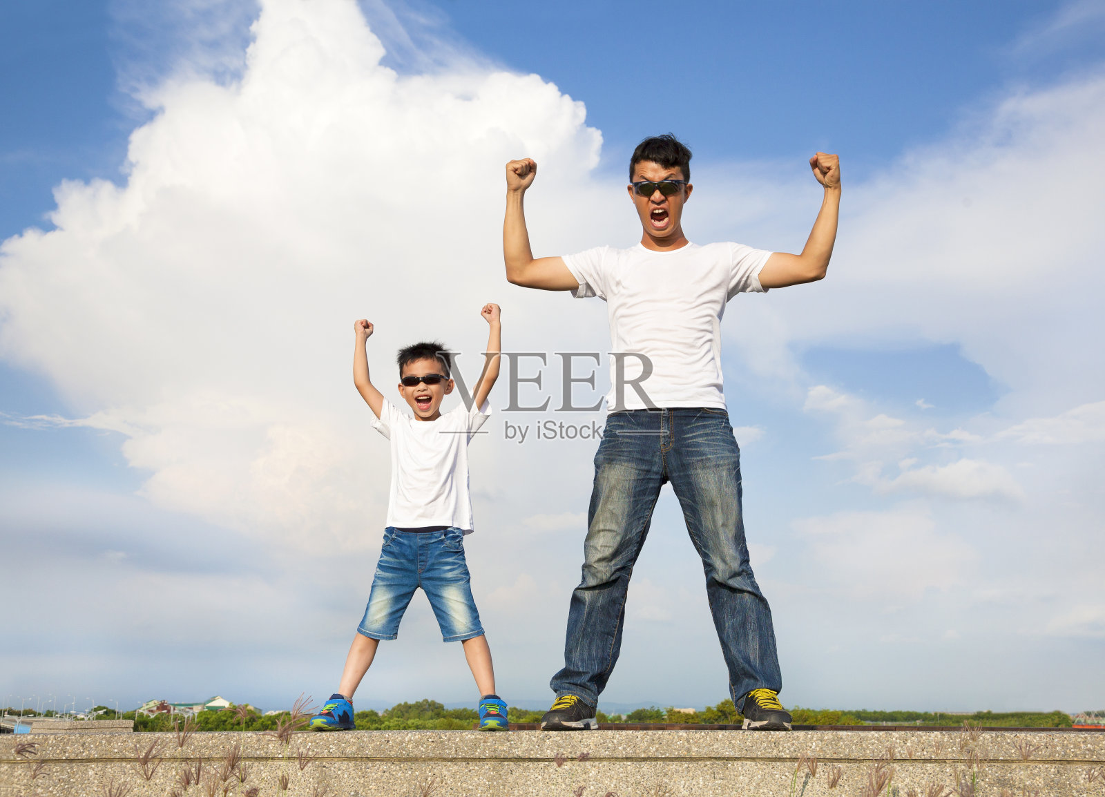父亲和儿子站在一起，举起双手照片摄影图片
