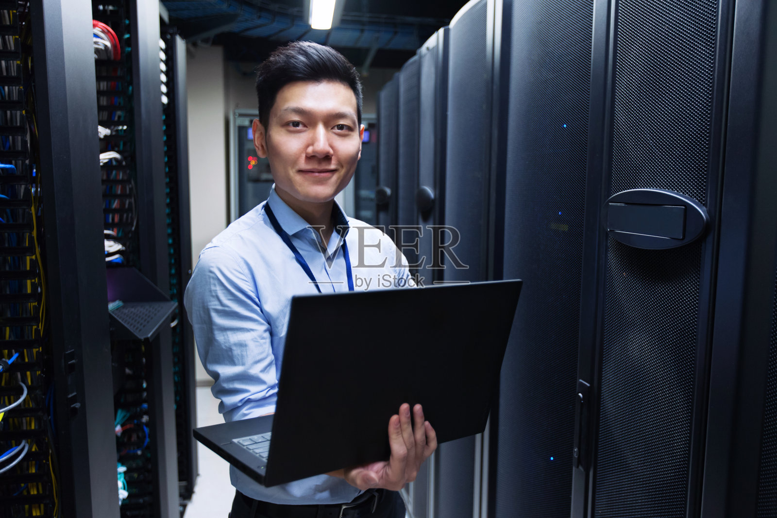年轻的IT工程师站在数据中心服务器附近照片摄影图片