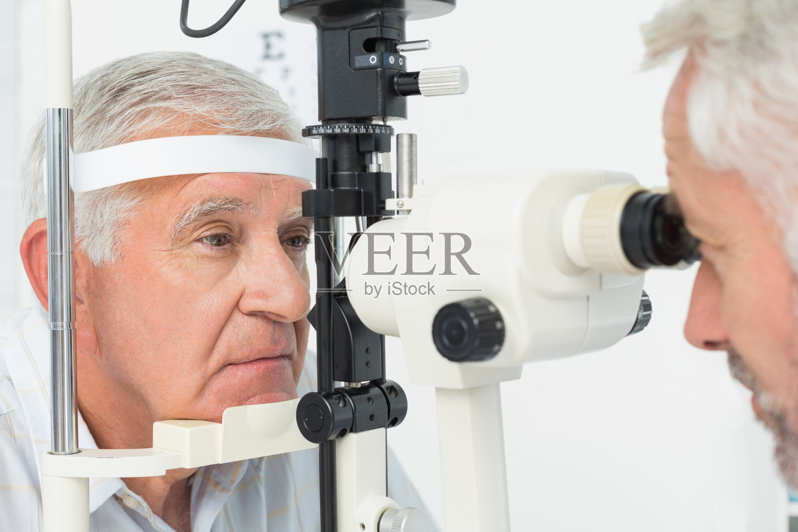 验光师为老年病人做视力测试照片摄影图片