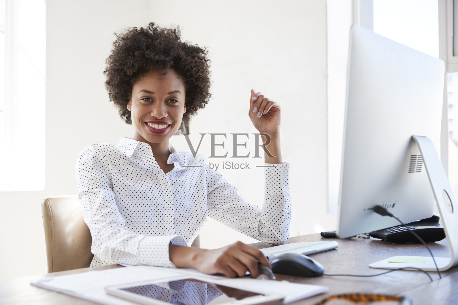年轻的黑人女性在办公室里对着镜头微笑，特写照片摄影图片