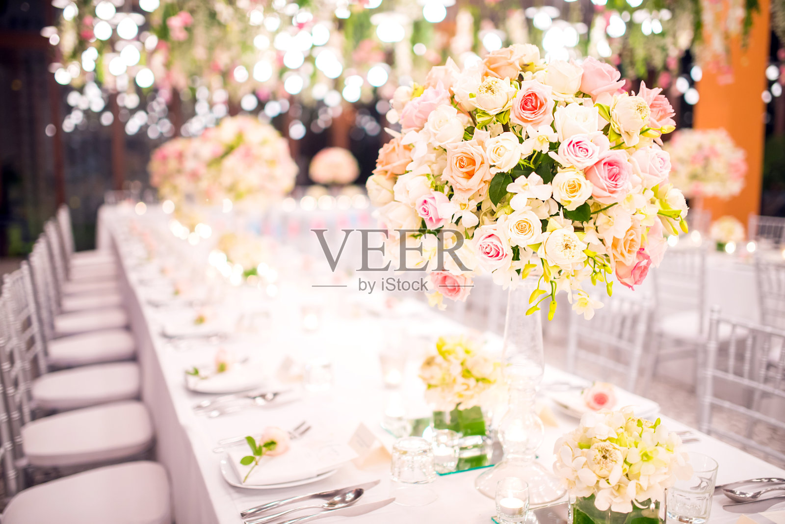 豪华婚礼的餐桌布置，桌上摆放着美丽的鲜花。照片摄影图片