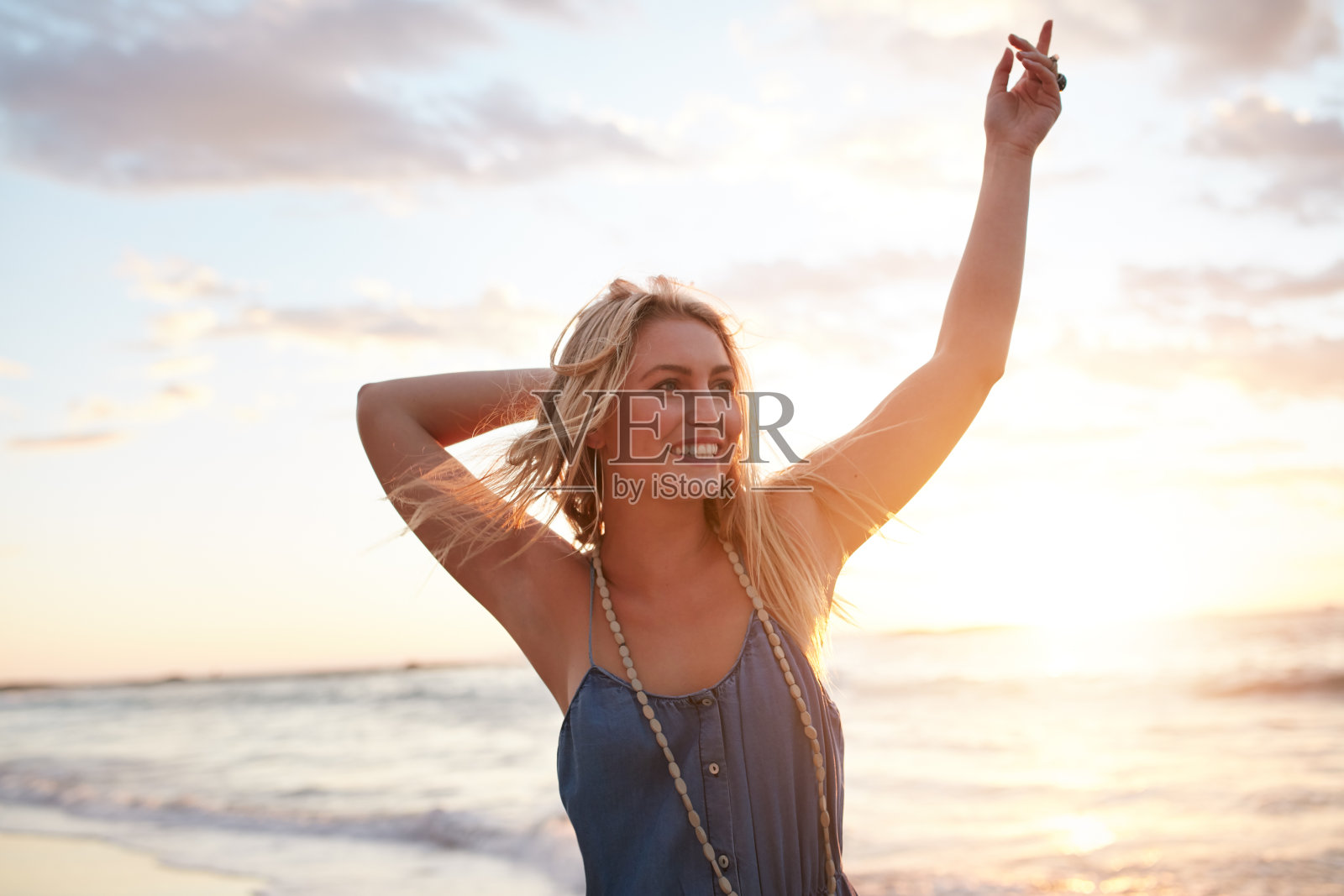 迷人的年轻女子享受在海滩上日落照片摄影图片