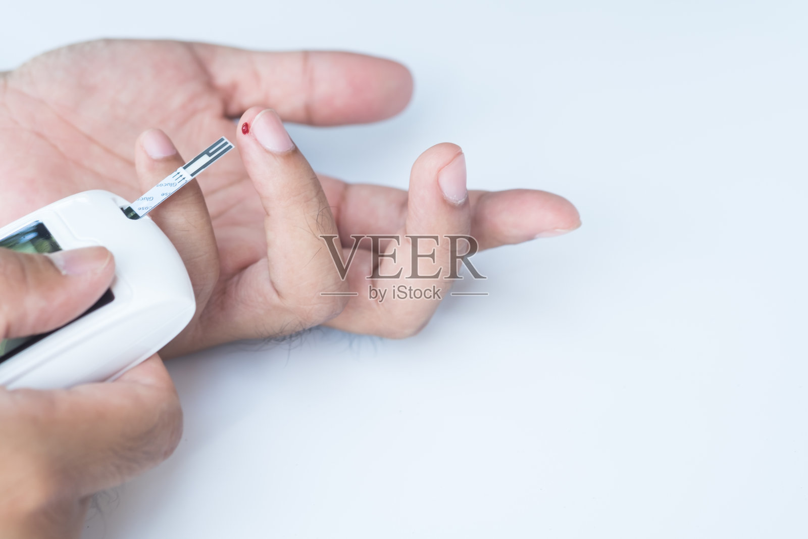 近亚洲男子的手使用柳叶刀的手指检查血糖水平的血糖仪，医疗保健和检查，糖尿病，血糖，和人的概念照片摄影图片