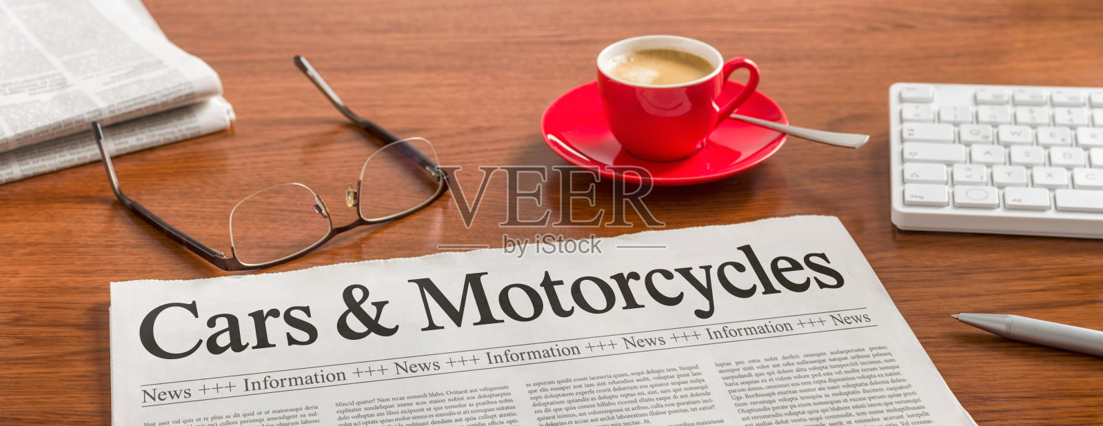 木桌上放着一份报纸——《汽车与摩托车》照片摄影图片