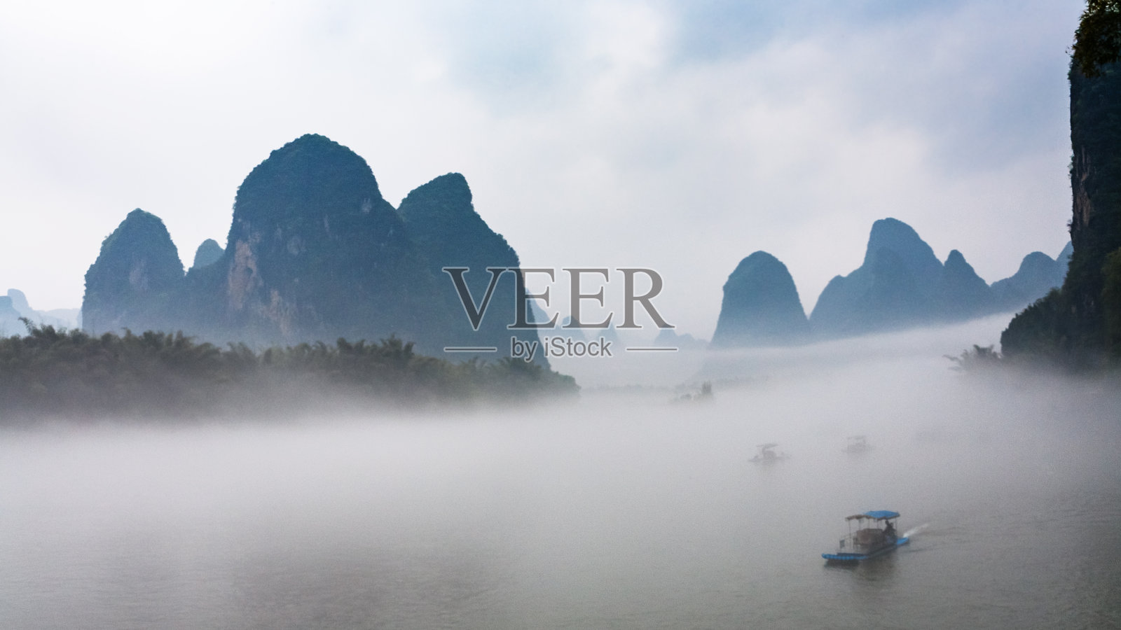 在兴坪镇附近的河上乘船可以看到雾照片摄影图片