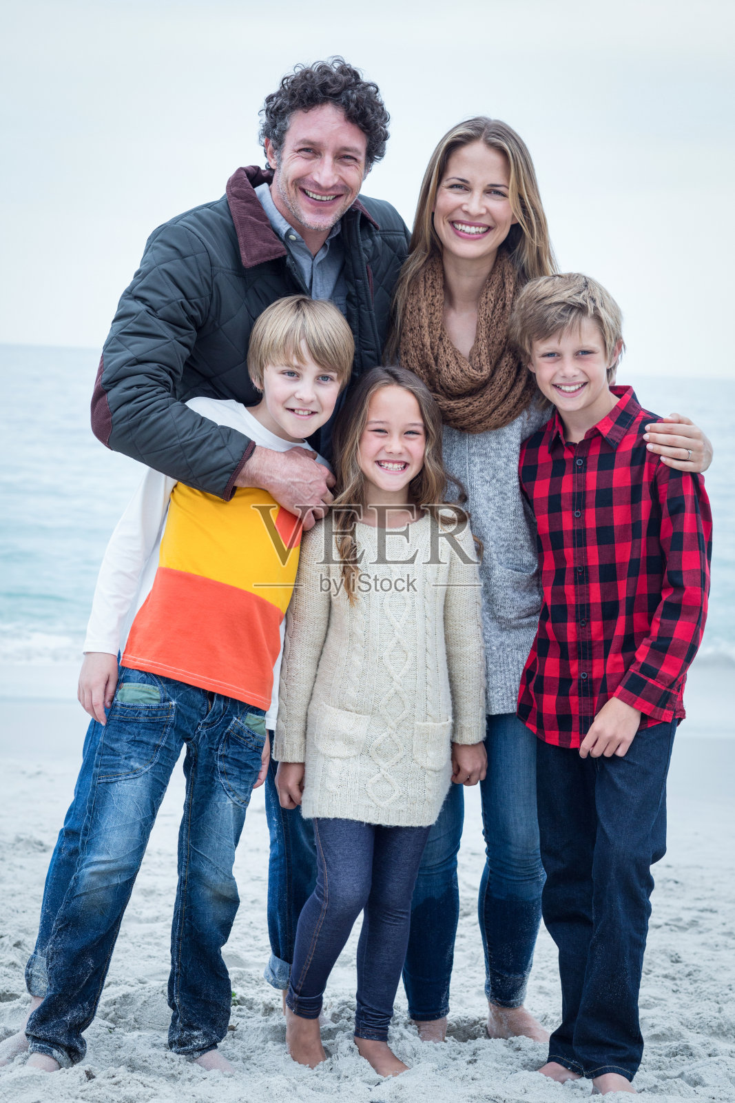 欢乐的一家人站在海边照片摄影图片
