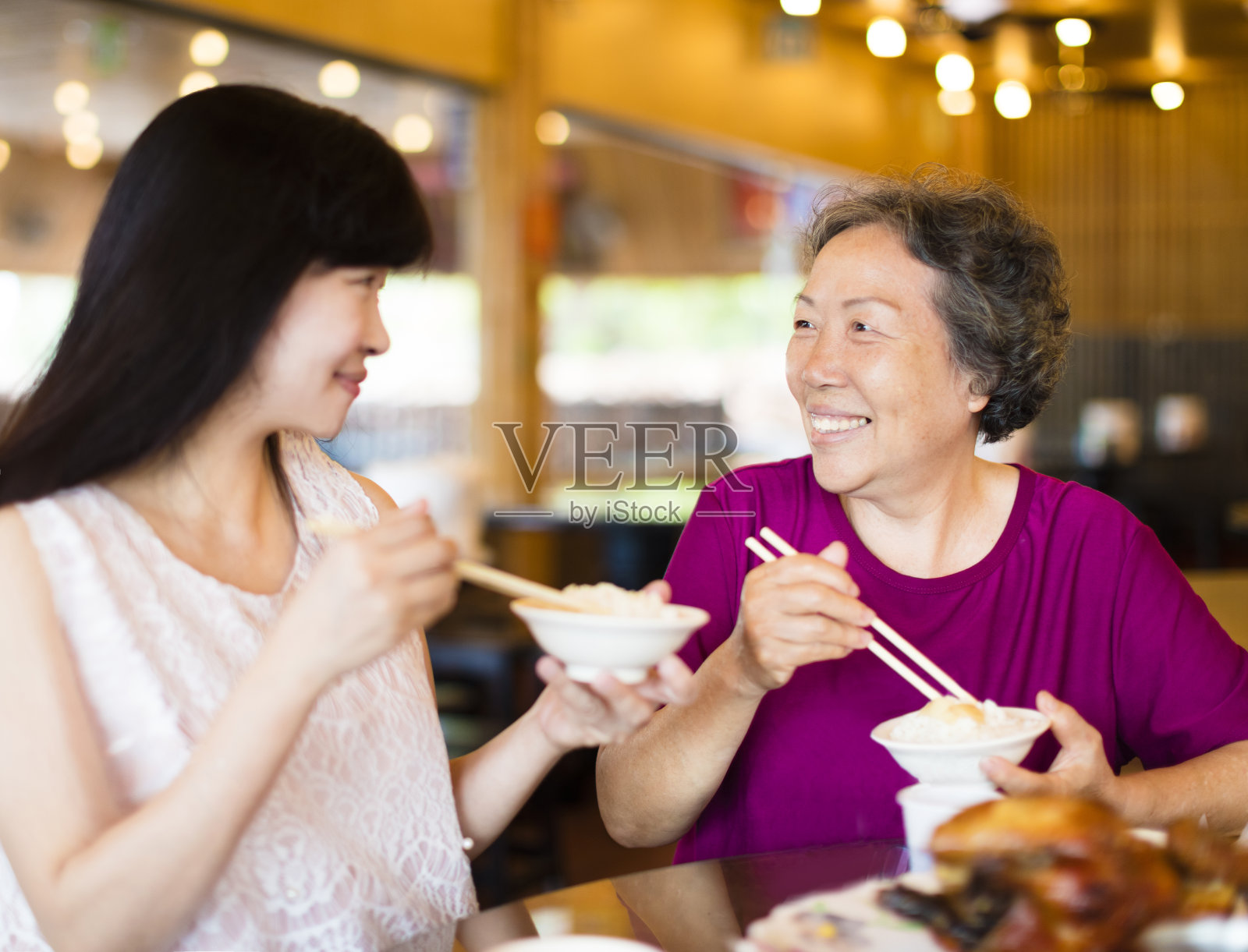 快乐的女儿和年长的母亲喜欢在餐厅吃饭照片摄影图片