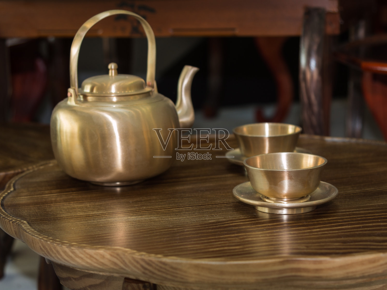 传统亚洲金茶壶和小木桌杯照片摄影图片