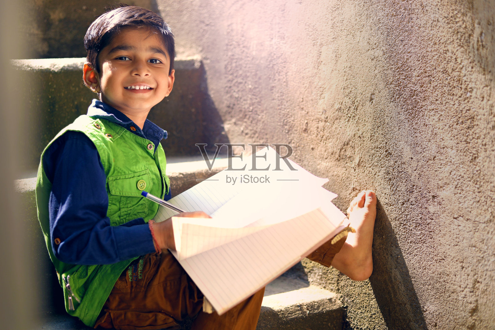 印度小孩在笔记本上写字照片摄影图片