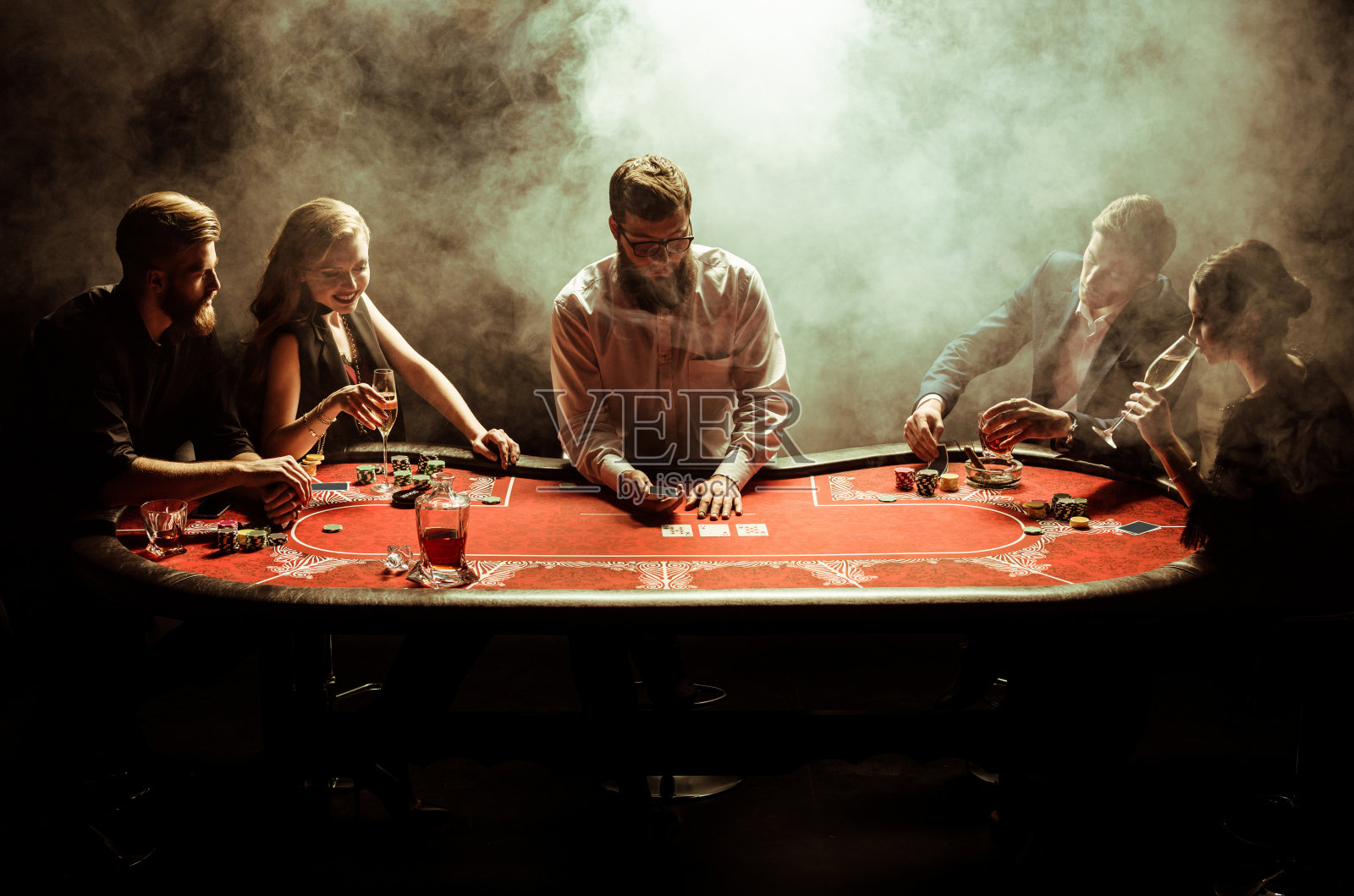 优雅的年轻男女在牌桌上玩扑克照片摄影图片
