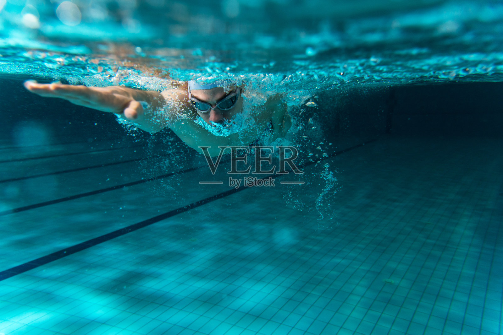 男性游泳运动员在游泳池里游泳照片摄影图片