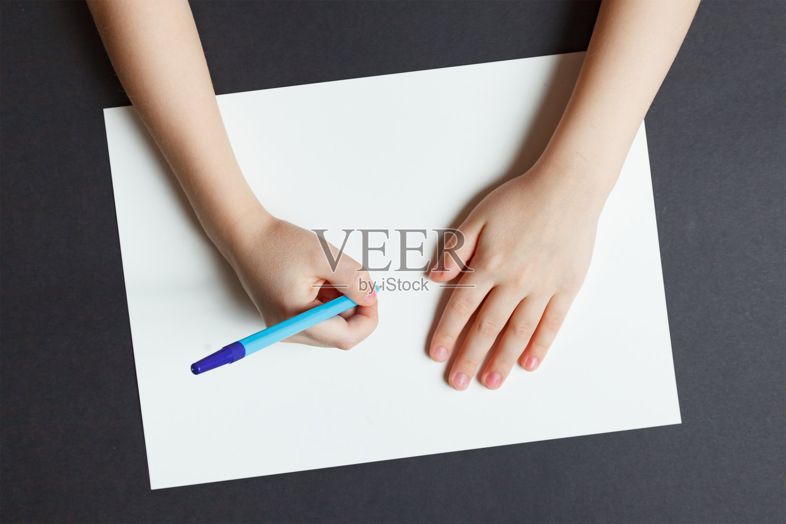 孩子们用一支笔在白纸上写字照片摄影图片