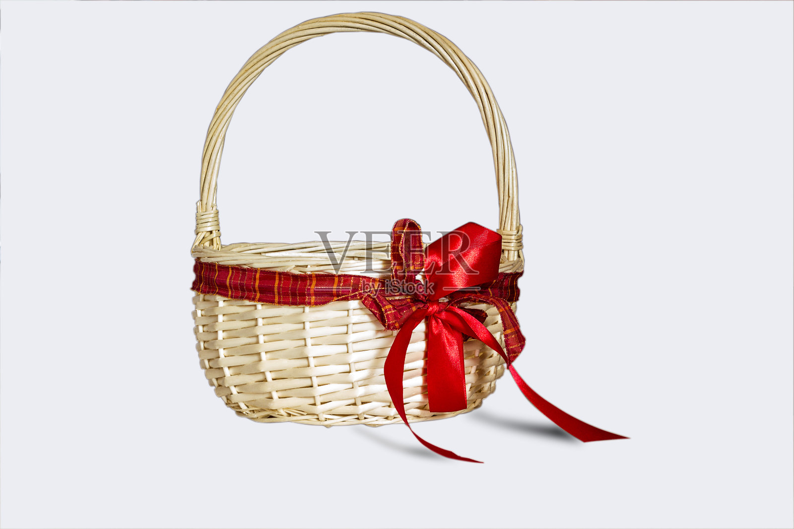 美丽的柳条篮子与红色的弓孤立在白色的背景照片摄影图片
