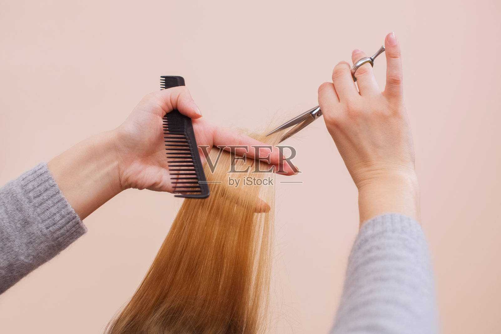 理发师用剪刀为一个年轻的女孩理发照片摄影图片