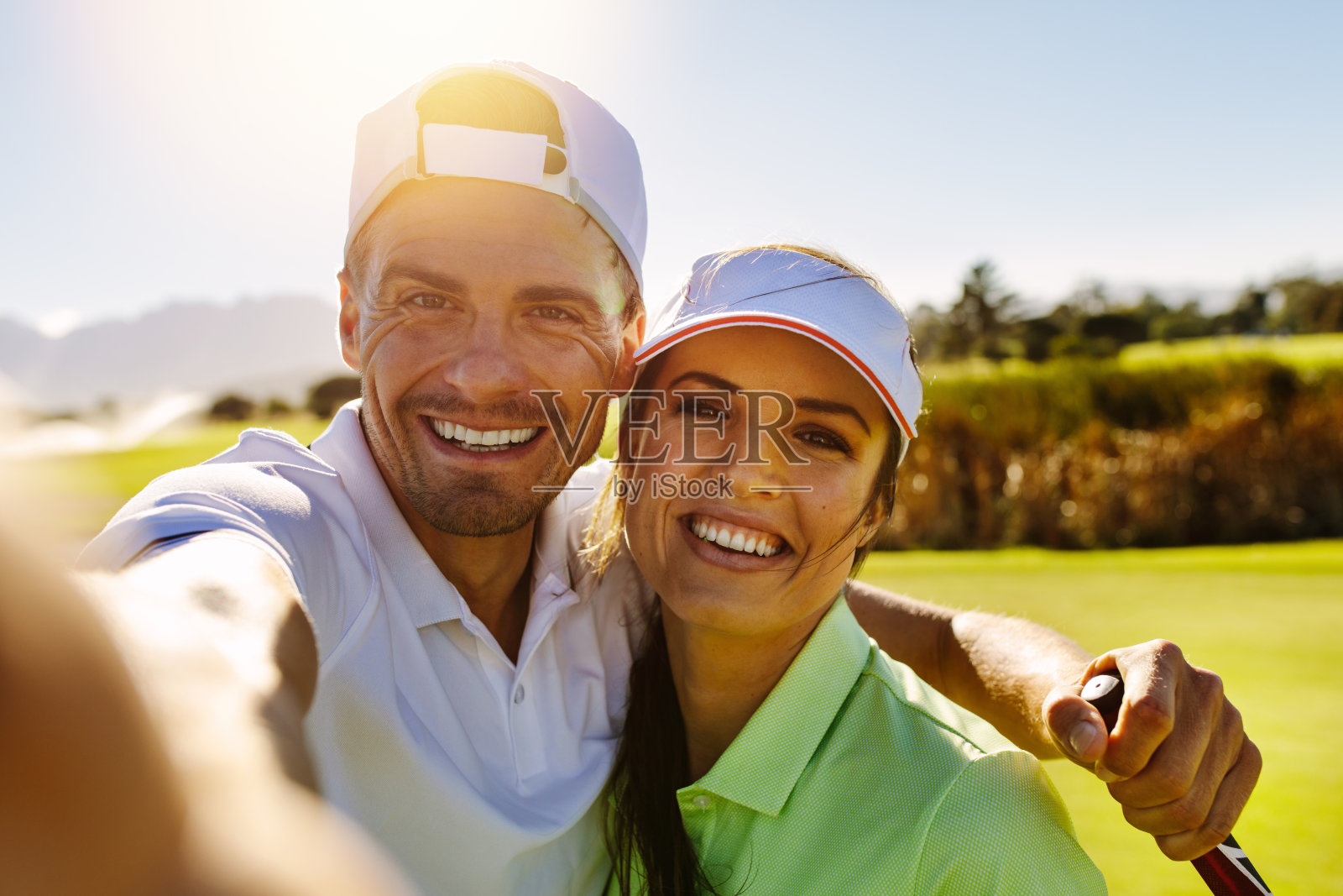 一对快乐的年轻情侣在高尔夫球场自拍照片摄影图片
