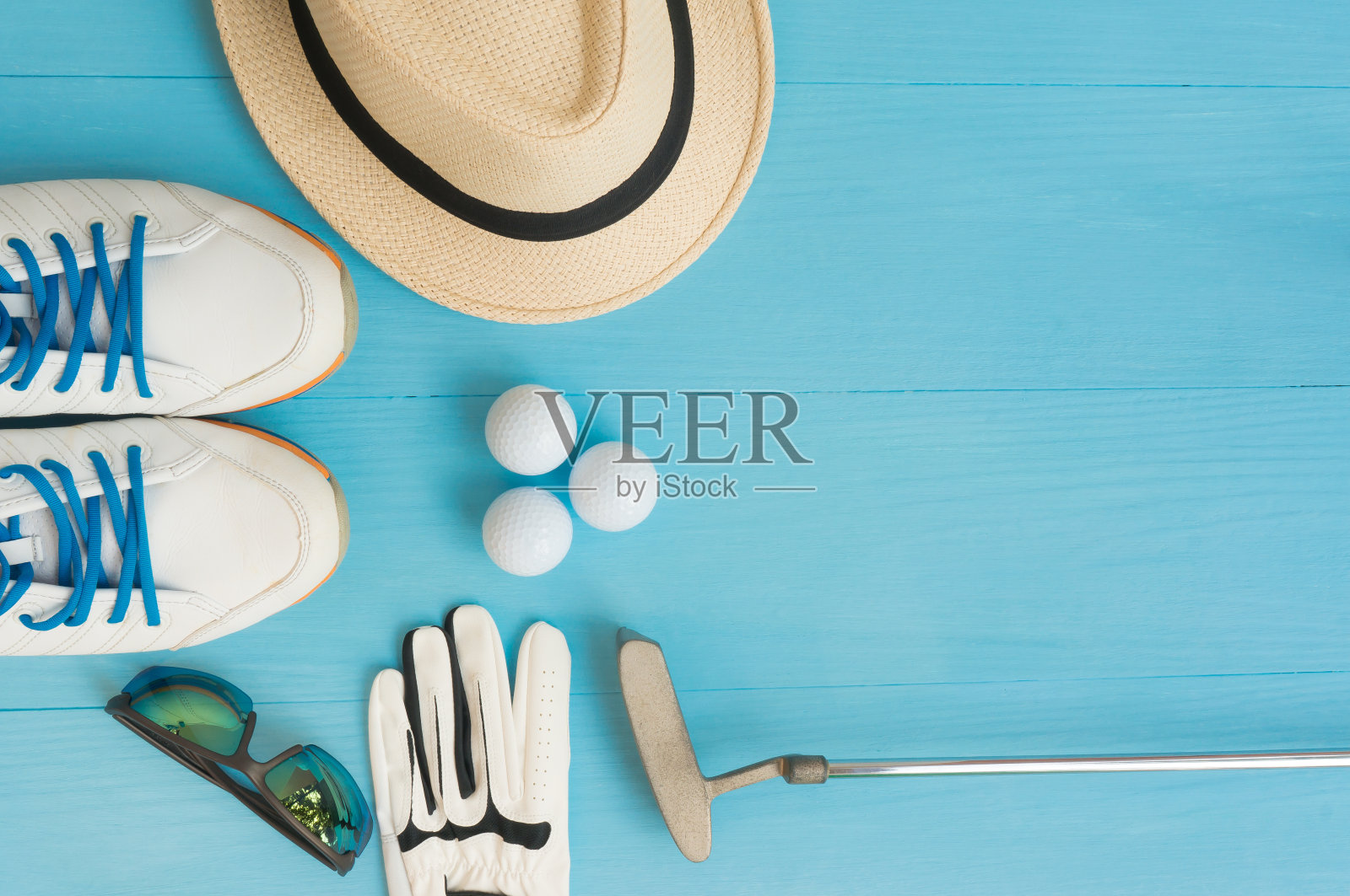 高尔夫概念:巴拿马草帽、手套、高尔夫球、高尔夫球杆、高尔夫球鞋、太阳镜放在木桌上。平铺与拷贝空间。照片摄影图片