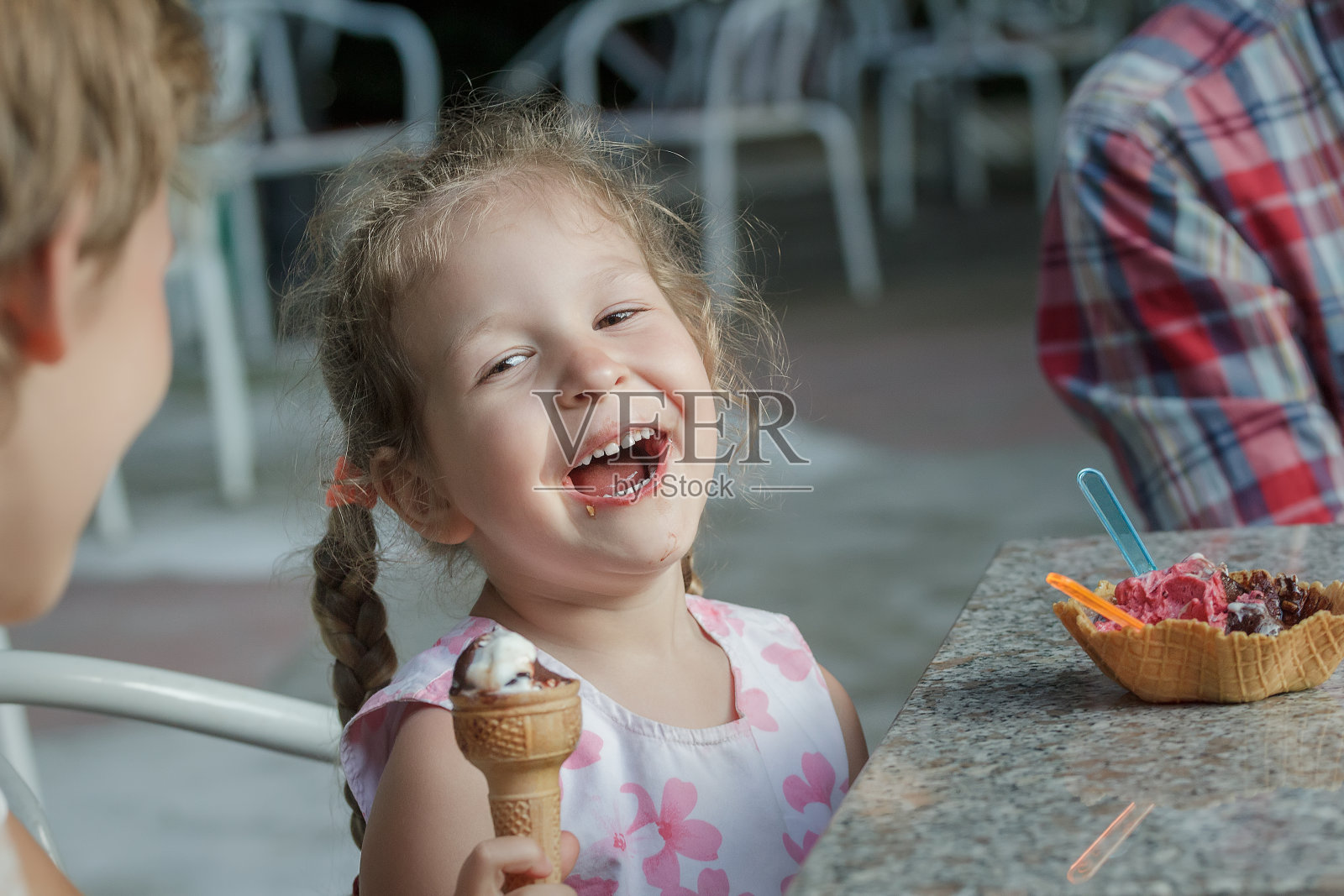小女孩和她的兄弟笑着吃意大利冰淇淋照片摄影图片