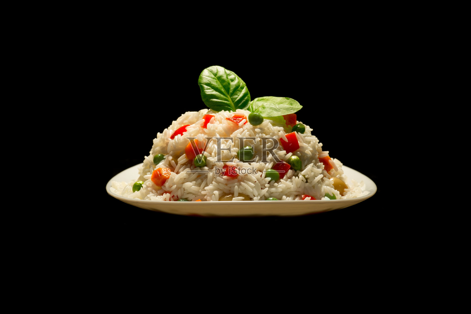 米饭配肉和蔬菜放在白色的盘子里。意大利调味饭饭照片摄影图片