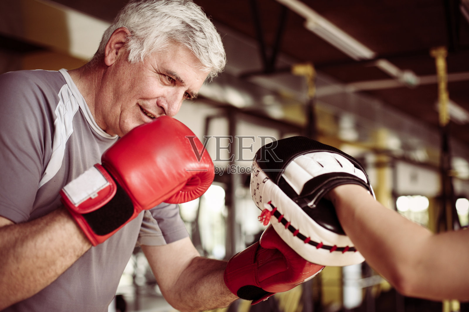 老男人在健身房拳击，老男人有私人教练。照片摄影图片