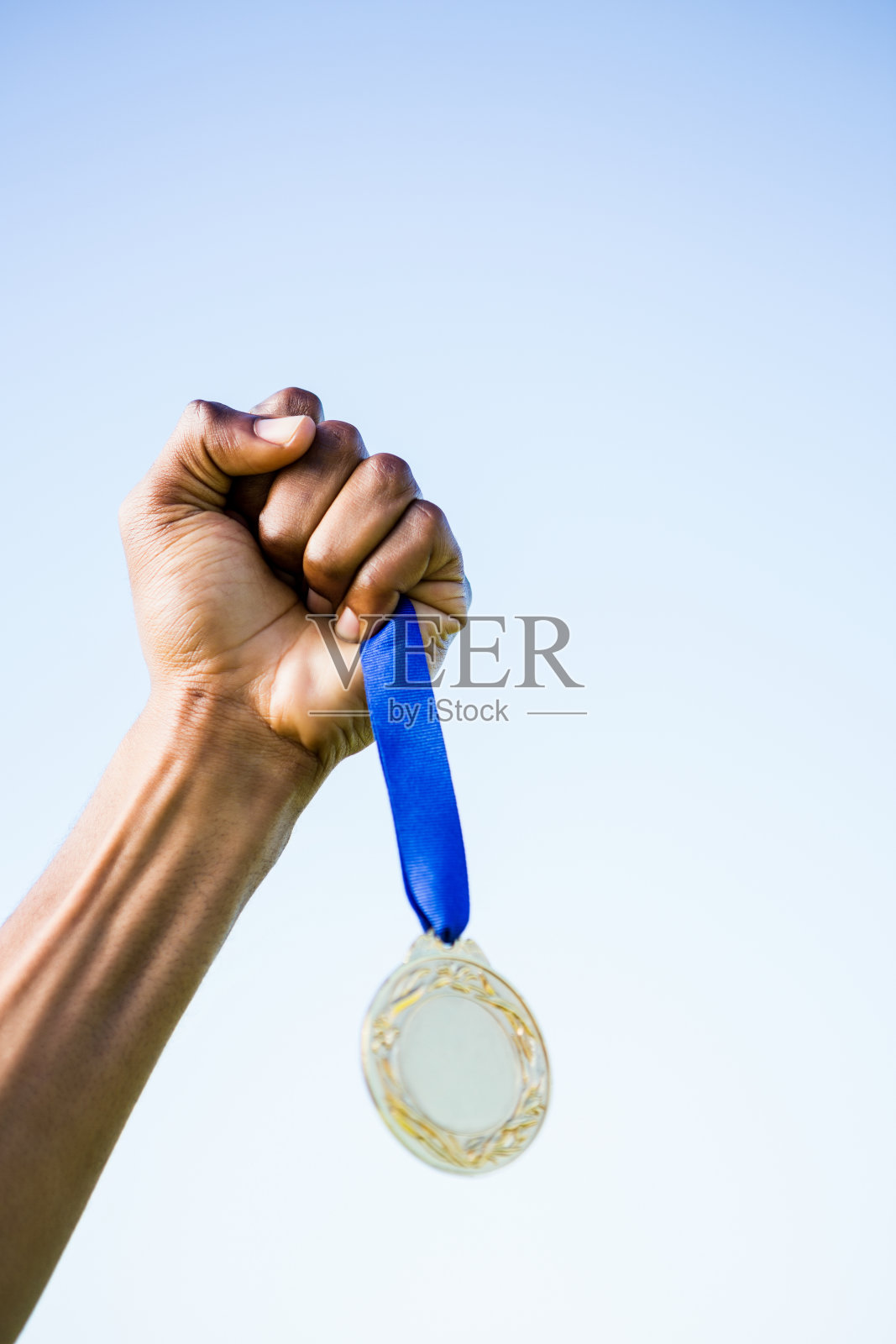 运动员在胜利后手拿金牌照片摄影图片