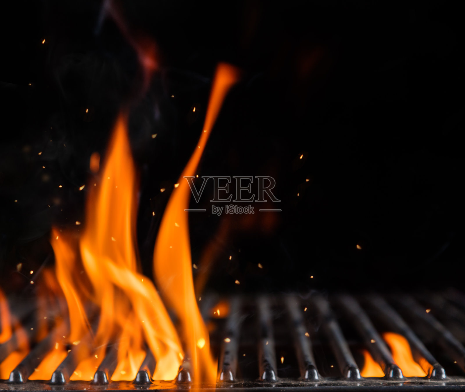 用明火清理燃烧的木炭烤架照片摄影图片