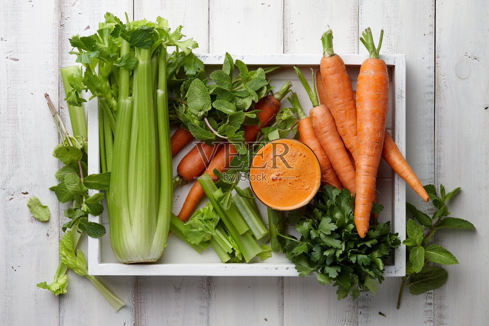 新鲜胡萝卜和芹菜汁在木托盘照片摄影图片