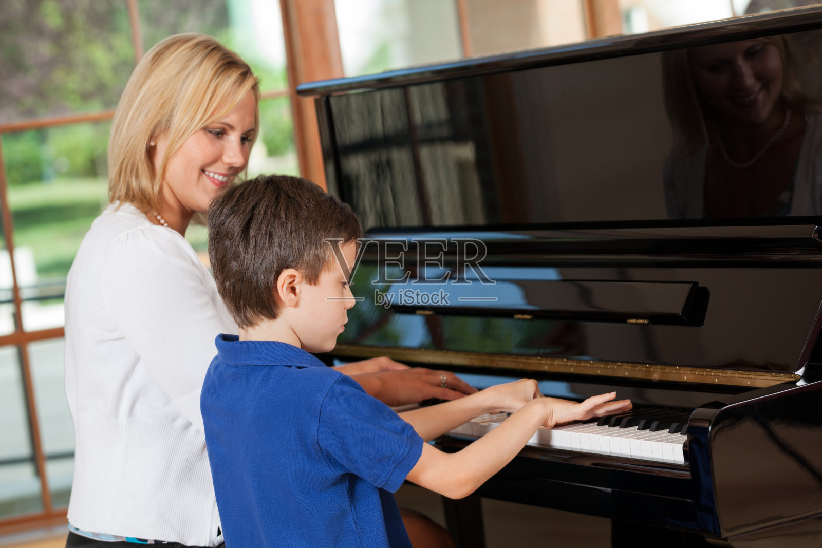 一个小男孩正在上钢琴课照片摄影图片