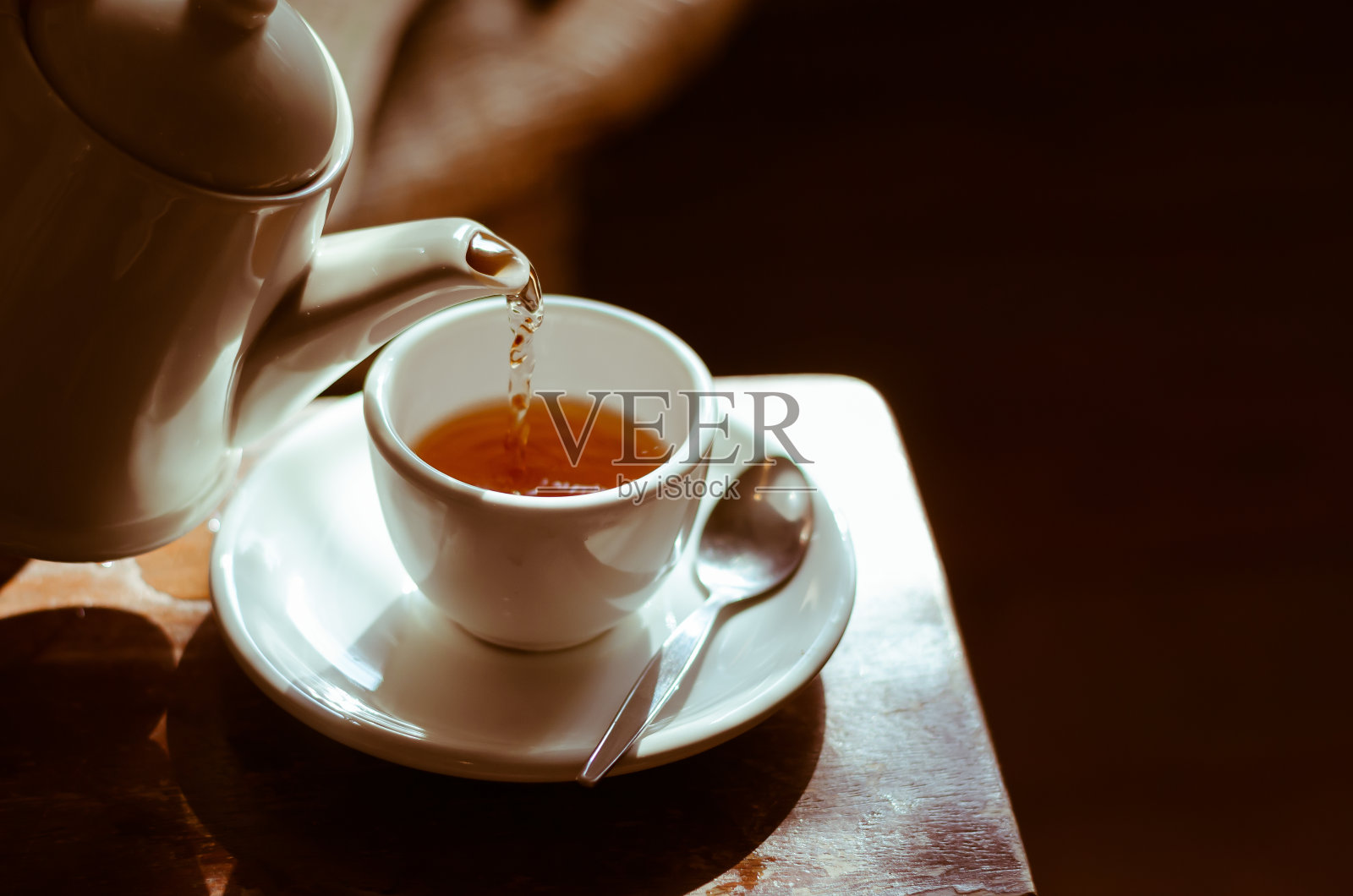 茶杯放在茶托上，倒着茶，照片摄影图片