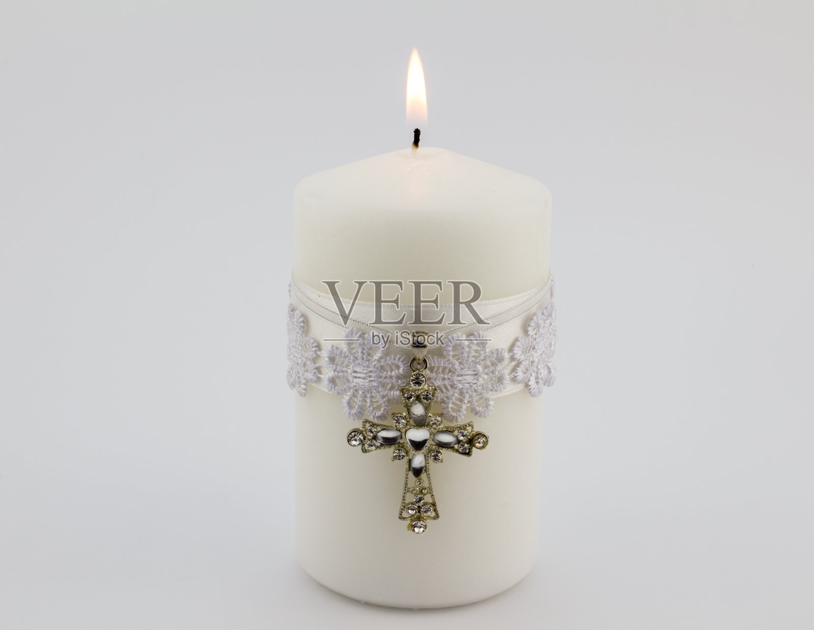 白色蜡烛与花边，丝带和基督教十字架吊坠孤立在白色背景照片摄影图片